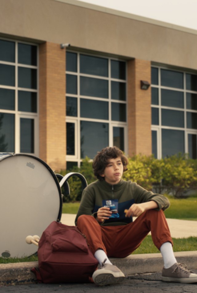 boy with drums outside of school