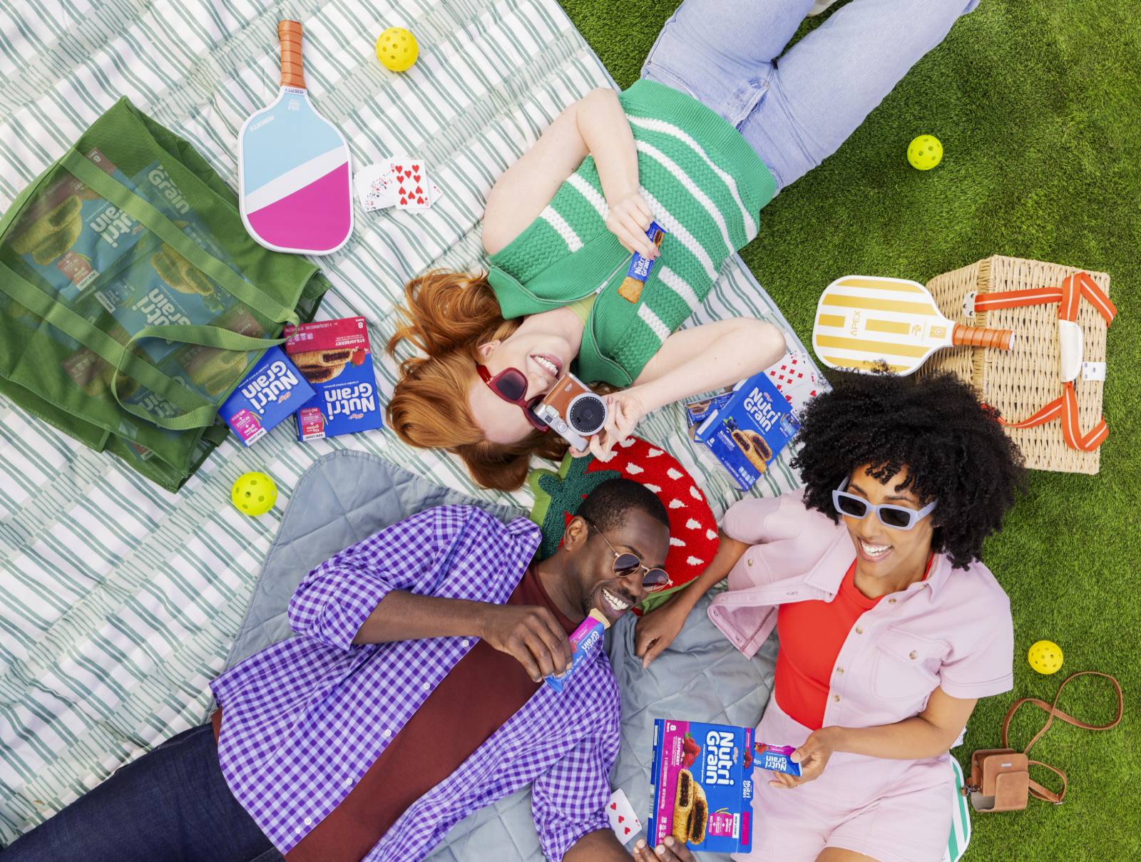 three friends having a picnic and snacking on Nutri-Grain bars
